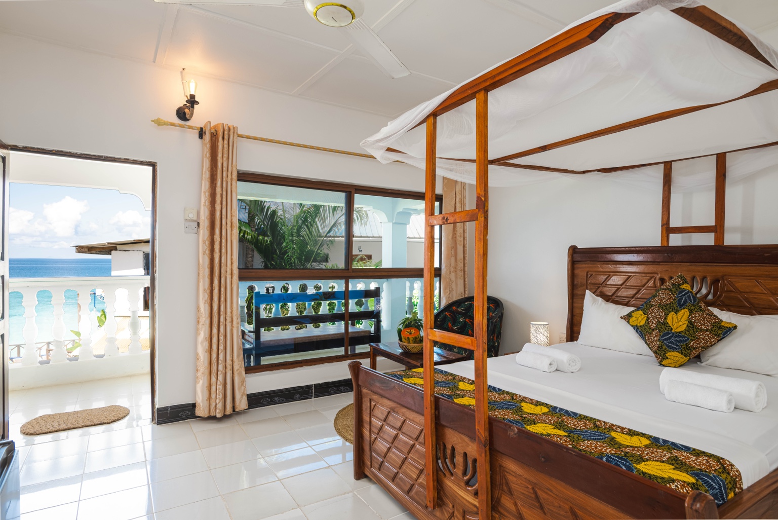 Queen Room with Ocean View — Canopy bed with a view towards the ocean